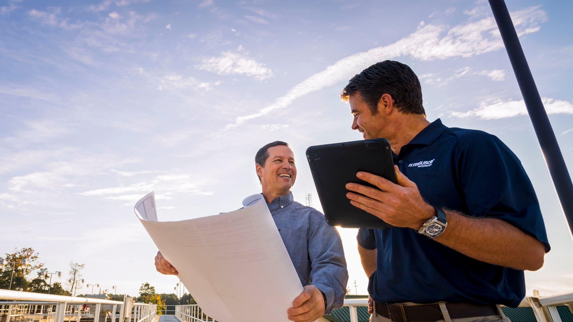 A Ferguson associate speaks with a customer on a bridge at a water treatment plant.